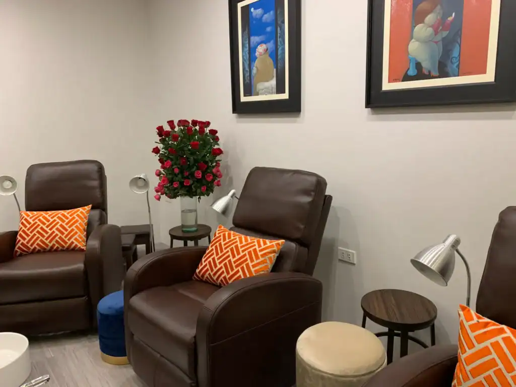 Comfortable nail spa lounge featuring plush chairs, vibrant artwork, and cozy decor for a soothing m.